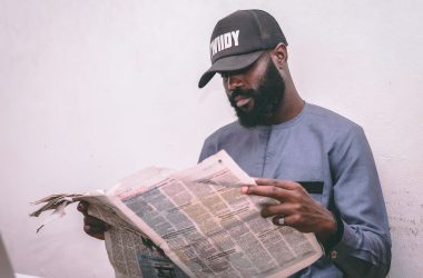 Adult man reading a newspaper indoors, wearing a cap and traditional attire. — Mastering SEO: Strategies to Boost Online Visi